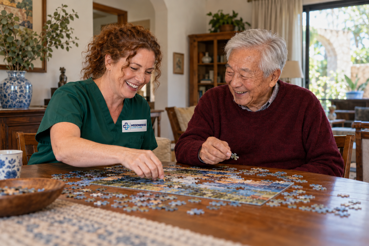 Illustrative companion in branded green scrubs enjoying a puzzle with an older Asian man
